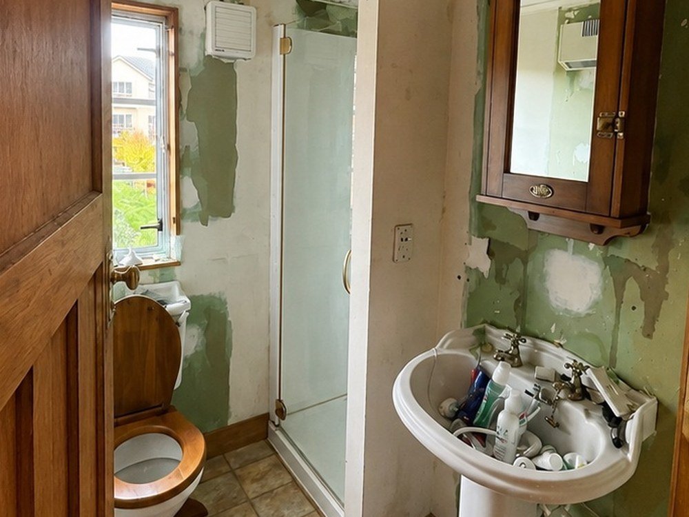 Bathroom before renovation with damaged wall lining, Wellington