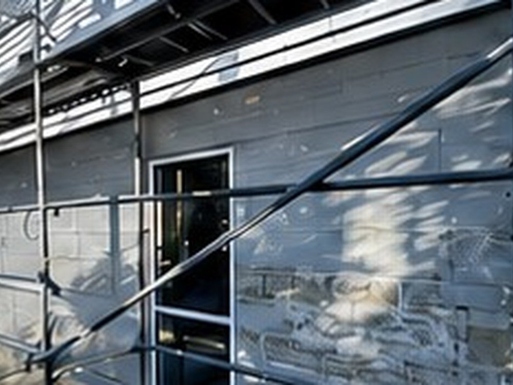 Two-storey house exterior before repaint, scaffolded, Wellington